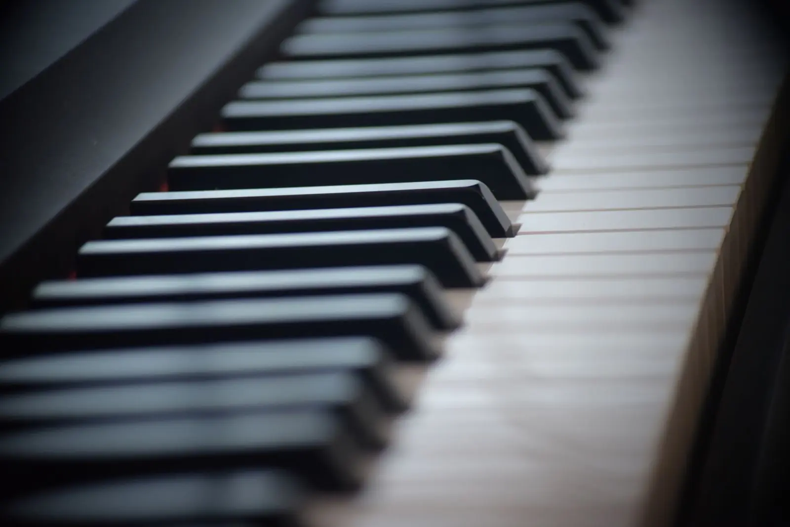 Close-up of black and white piano keys receding into soft focus