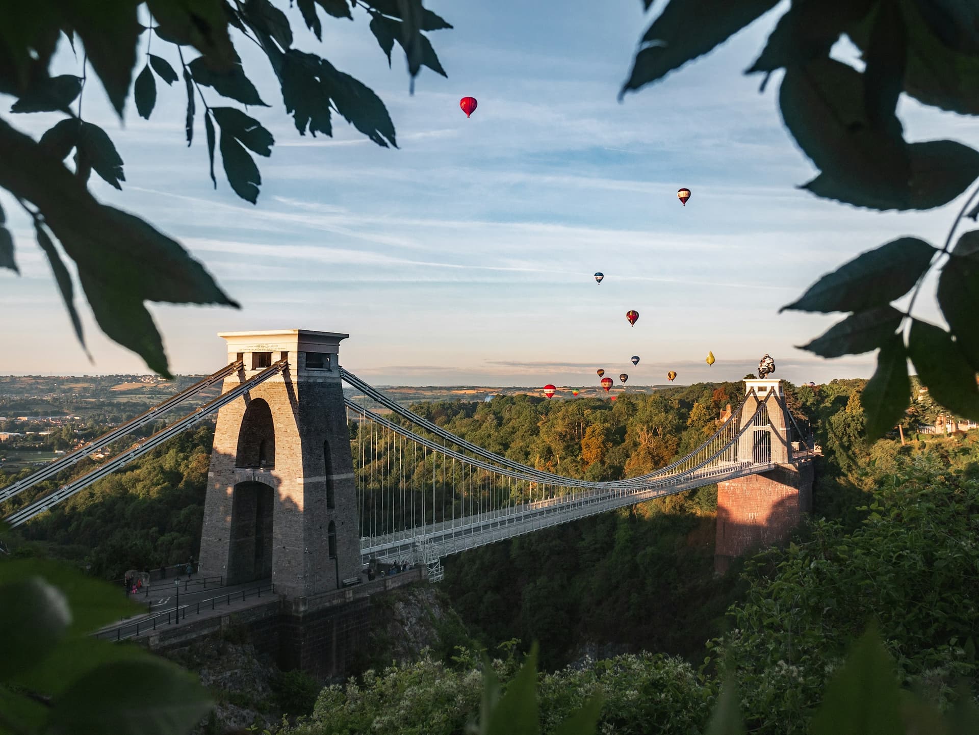 Clifton Suspension Bridge with hot air balloons overhead.