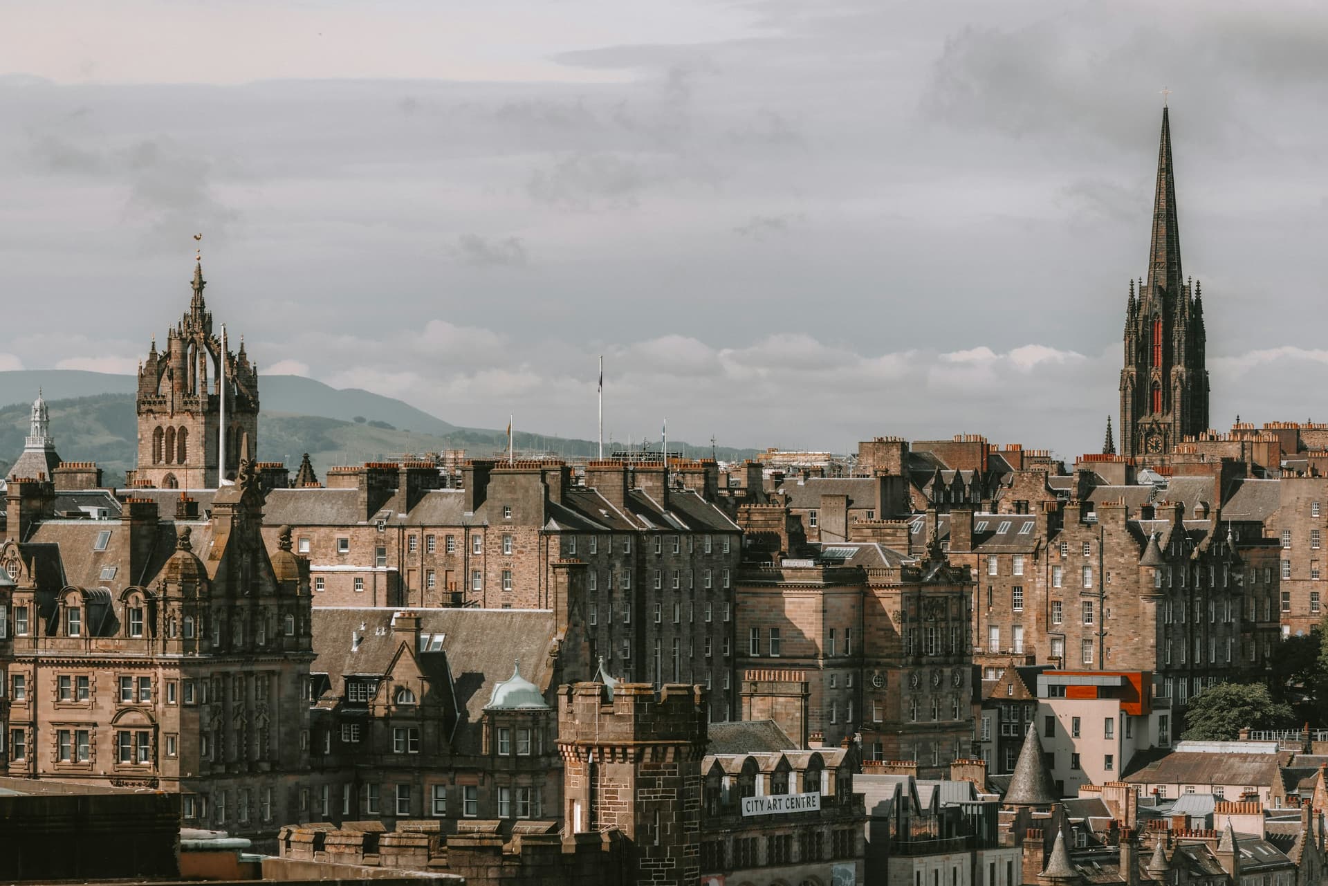 Edinburgh Old Town rooftops and spires under a moody sky.