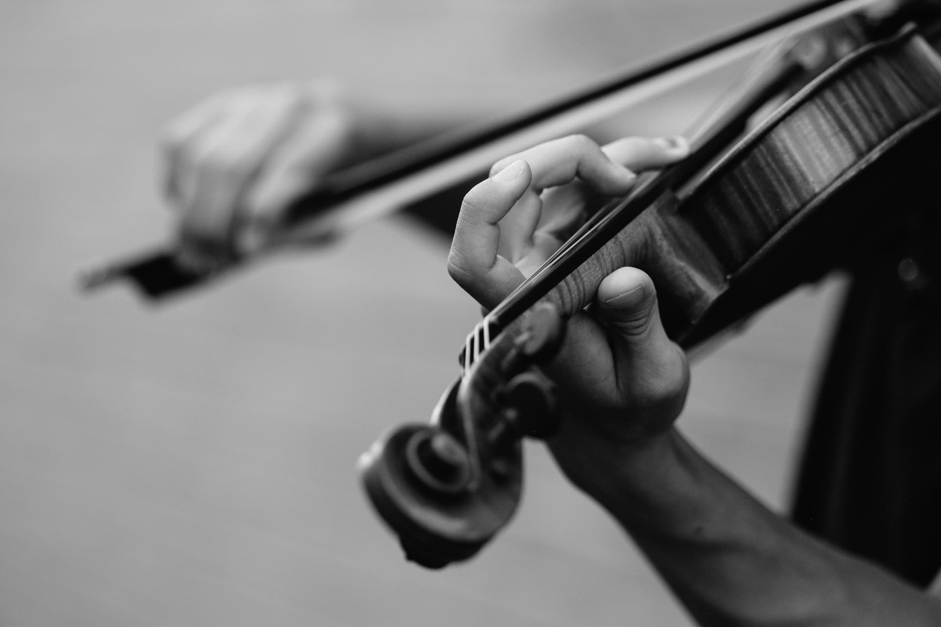 A violinist bowing, photographed in black and white.