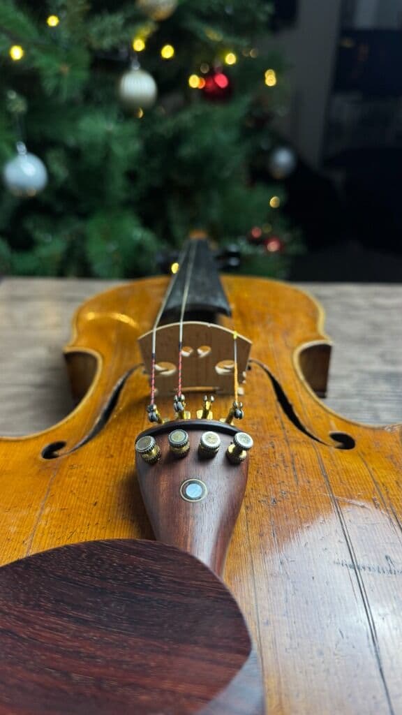 Close-up of a bowed string instrument in warm light.