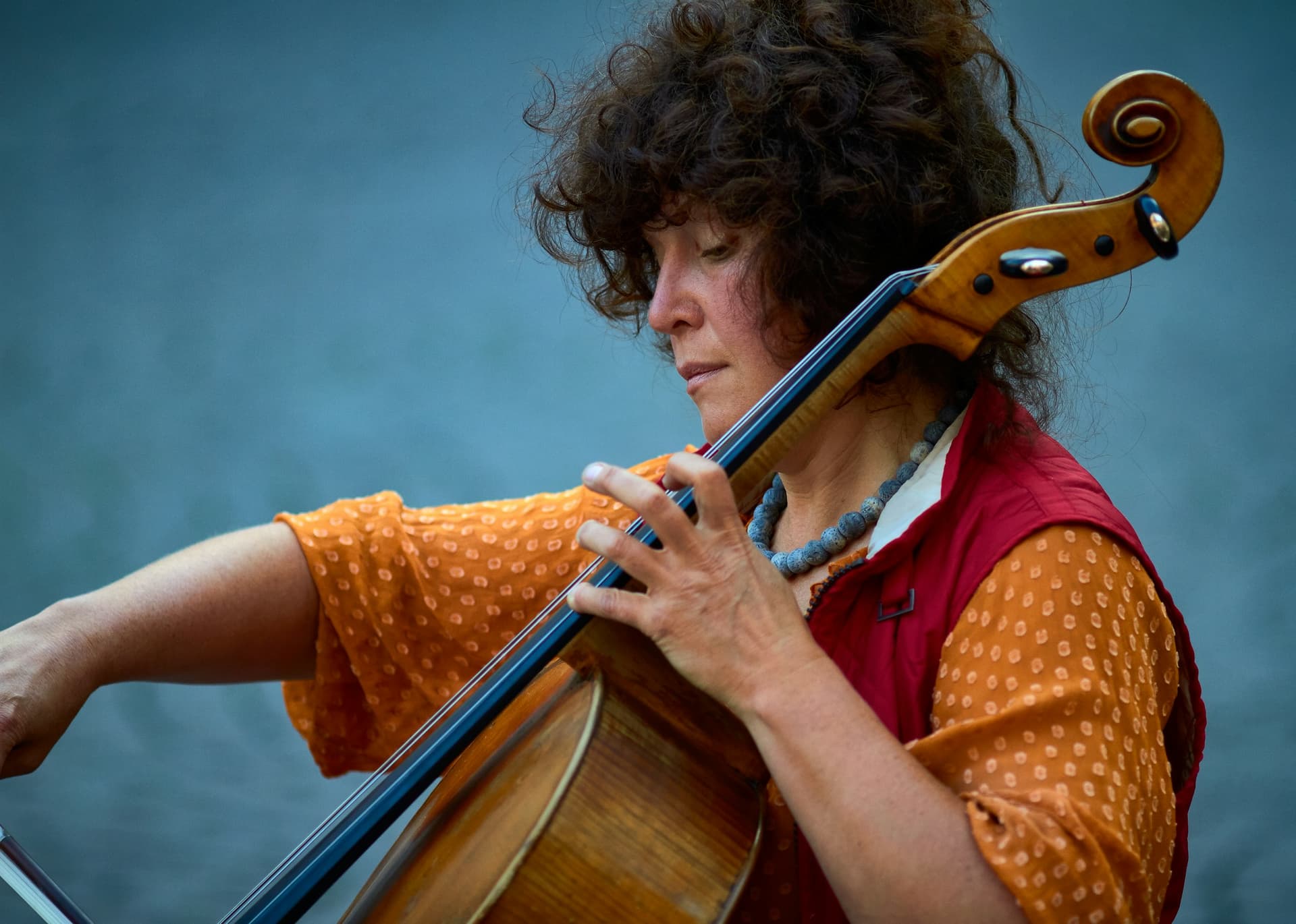 A cellist playing outdoors in warm colours.