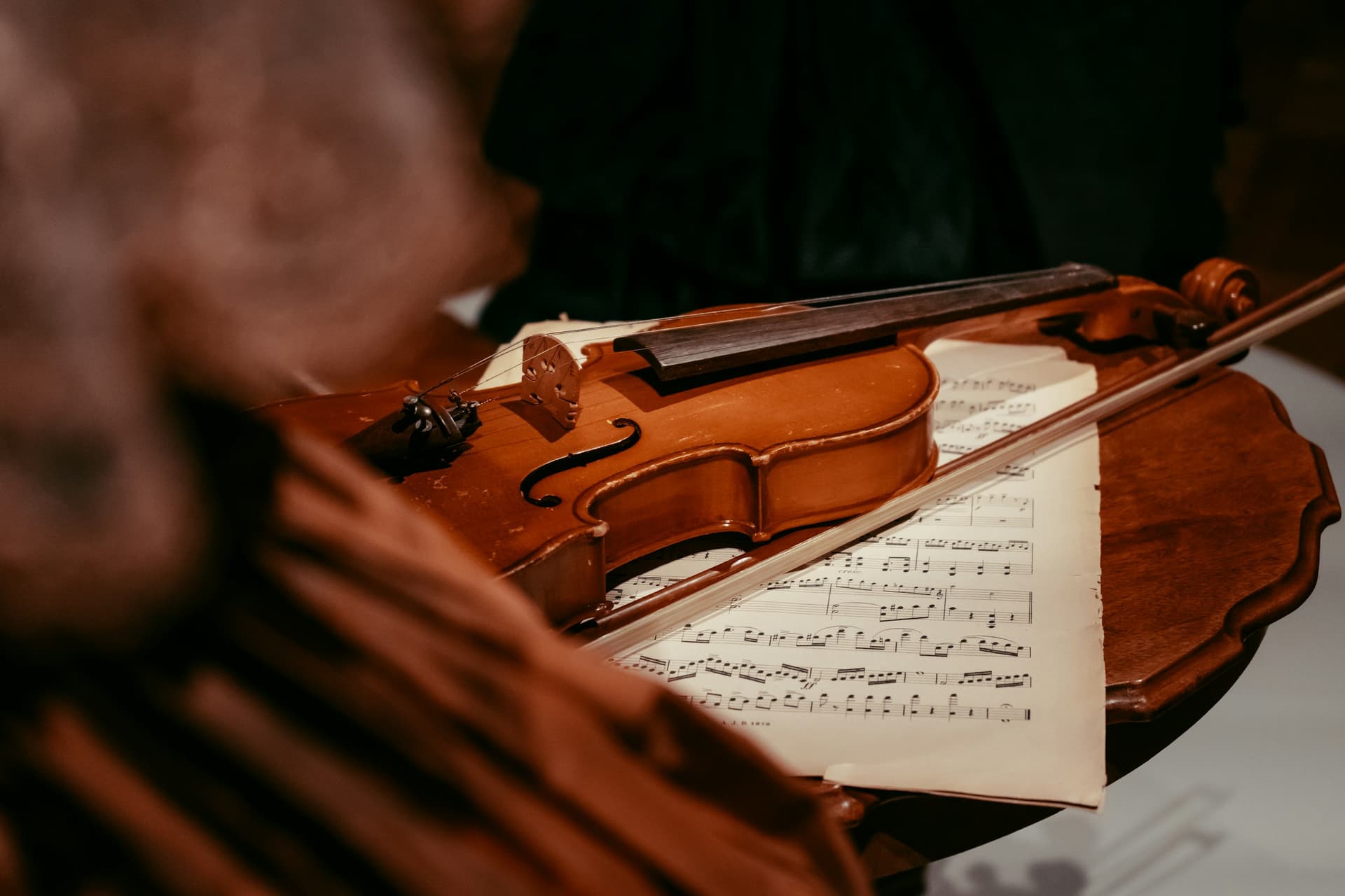 A violin and bow resting on handwritten sheet music.