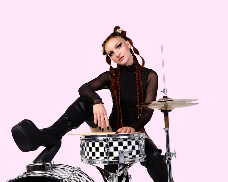 Klara Bohmova, a LearnMusic drum teacher, sitting at a drum kit.